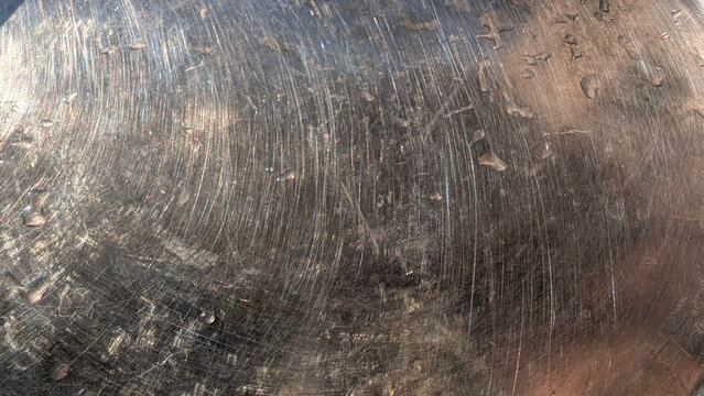 Scratched brushed metal with circular scratches and water drops