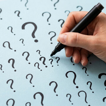 Hand drawing question marks on light blue background concept of confusion uncertainty and inquiry
