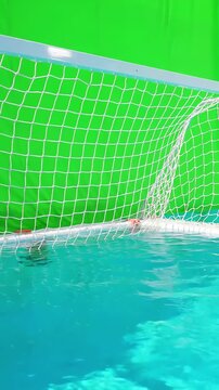 Water polo goal net with white frame and mesh floating on calm pool surface against a bright green screen background