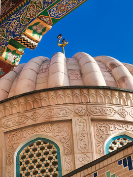 Ribbed dome and carved stone facade of Hazrat Khizr mosque in Samarkand with crescent finial against blue sky. Ideal for travel publications, cultural heritage features, and architectural studies.