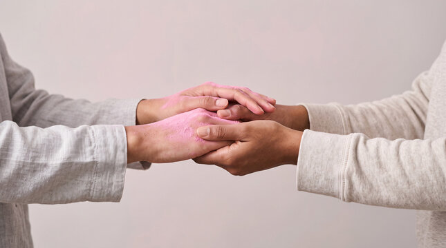Deux personnes se tenant les mains sur un fond rose