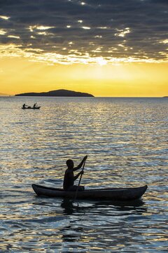 Man in a little fishing boat at sunset, Lake Malawi, Cape Maclear, Malawi