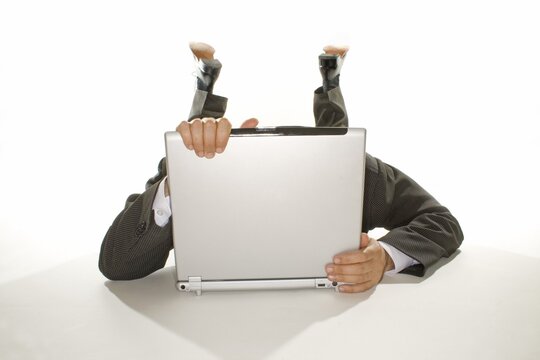 Business man lying behind a notebook
