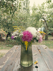 Fresh autumn bouquet of asters and wildflowers in glass vase outdoors © emerald17