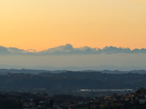 Beautiful sunset drone/scenic view over the rolling hills, green vineyards, and rural landscape of Castagnole delle Lanze, located in the Langhe and Monferrato wine region, Asti province, Piedmont, It
