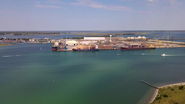 Docked vessels and warehouses dominate the approaching Port of Morehead City waterfront.