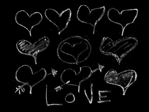 Hand drawn white chalk hearts and love text set on black background illustration