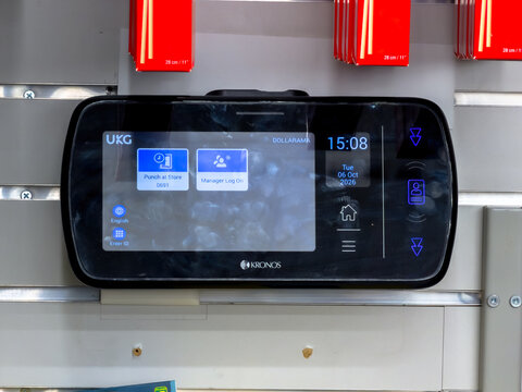 Calgary, Alberta, Canada. October 11, 2026. Close-up view of a digital UKG Kronos employee time clock terminal in a Dollarama store.