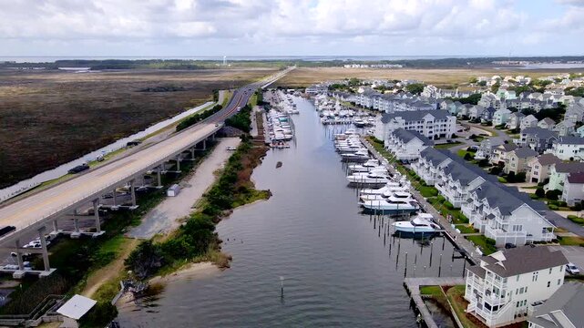 A marina basin stretches between the coastal road and rows of waterfront homes.
