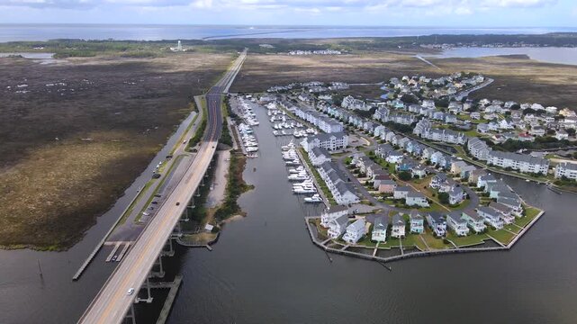 A residential peninsula turns into view between marina berths and open coastal water.