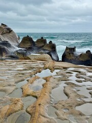 Eroded rock formations and tide pools reflecting the sky at Yehliu Geopark in Taiwan © Ben
