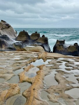 Eroded rock formations and tide pools reflecting the sky at Yehliu Geopark in Taiwan