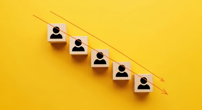 Workforce Reduction Trend Illustration Showing Downward Trend With Wooden Blocks And Red Arrow On Yellow Background Representing Layoffs Or Attrition