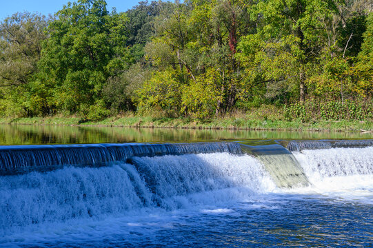 Scenic waterfall flowing over a weir on a river.