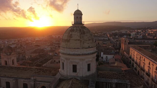 sunset flying clockwise around dome of Noto Cathedral in Sicily