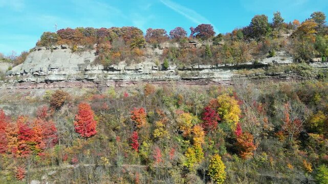 Panning shot moving right Niagara Gorge aerial from over the Niagara River in Lewiston, western New York, United States. Autumn fall foliage tree leaves during October, 2024.