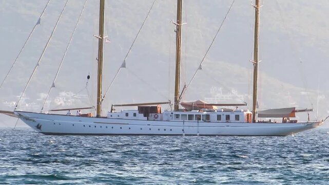Three masted sailing schooner floating on sea