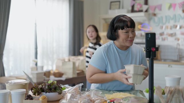Woman Cooking Baking in Kitchen Live Streaming Online Food Preparation Recipe Broadcast with Smiling Adult Host Presenting Prepared Dishes and Cheerful Home Content Creation Setup