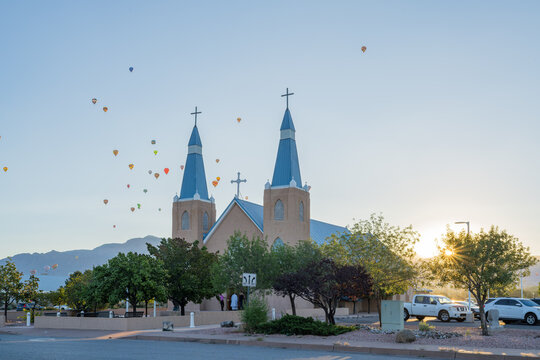Church with hot air balloons in sky at sunrise