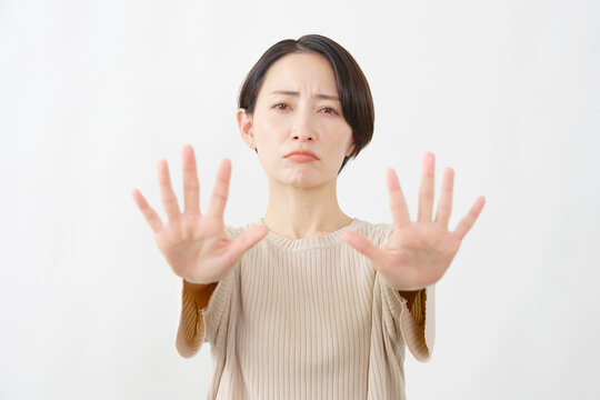 両手を向けて制止する女性　白背景