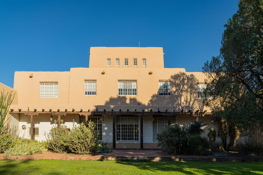 Adobe Style Building Facade with Wooden Pergola and Landscaping