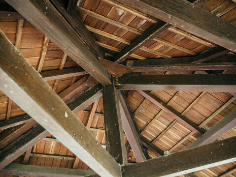 Wooden Gazebo Roof Framework With Intersecting Timber Beams and Planks
