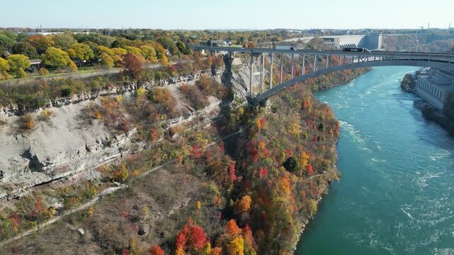 Niagara Gorge aerial over the Niagara River and the international border crossing Queenston-Lewiston bridge between New York and Ontario, Canada. Autumn fall foliage tree leaves. October, 2024.