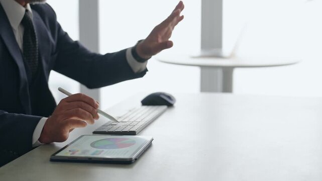 タブレットPCを使って作業する男性ビジネスパーソン。VR、バーチャル、画面、タッチ、操作、ビジネス