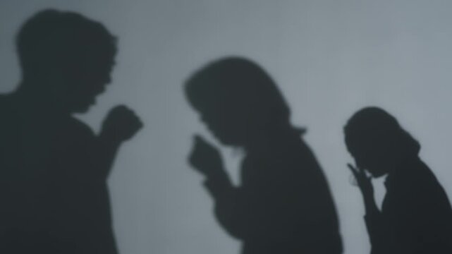 Silhouettes of people coughing