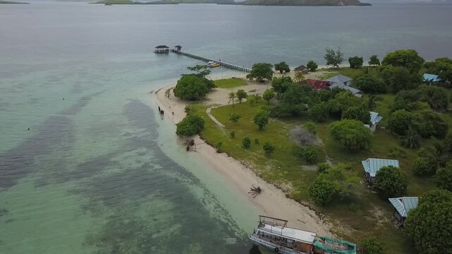 A stunning aerial view of Pahawang Island, Lampung, featuring boats and small vessels amidst lush, beautiful green trees.