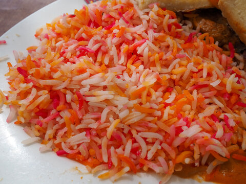 Traditional Somali Mandi Rice with Vibrant Orange and Yellow Food Coloring Accents, Close-Up Side View
