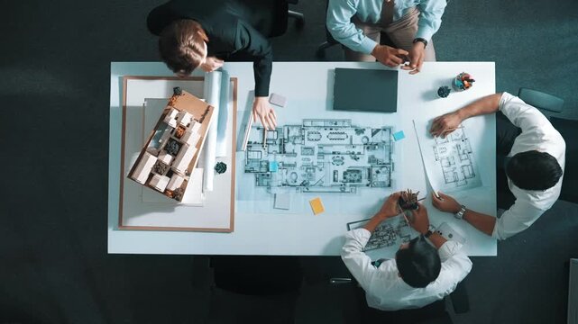 Top aerial view of project manager or civil engineer writing at blueprint and planning building design. Aerial view of architect working together at meeting table with document placed. Alimentation.