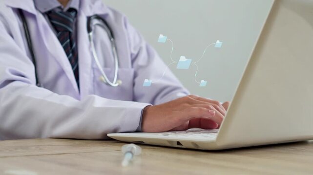 Close-up of doctor typing on laptop with animated central file network and media graphic