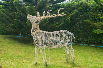 Reindeer Sculpture in Garden: A charming wire-frame reindeer sculpture stands proudly in a manicured garden. © bubbers