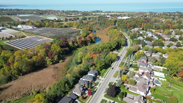 Aerial panning moving forward west from Martindale Pond over Richardson's Creek towards Lake Ontario in north St. Catharines, Ontario, Canada on a sunny Autumn day in October, 2024. 