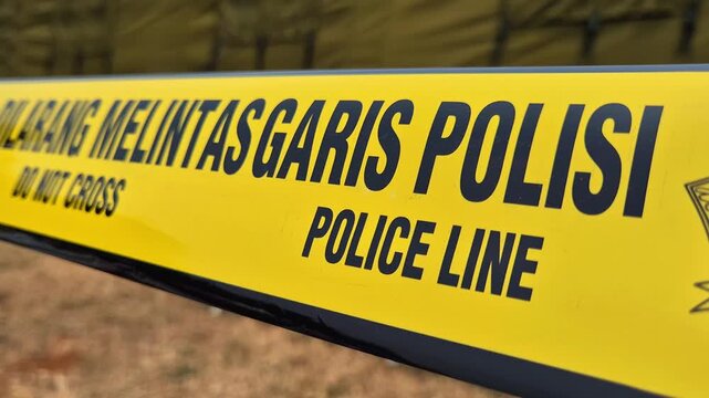 Yellow Indonesian police line tape with DO NOT CROSS and POLICE LINE text.