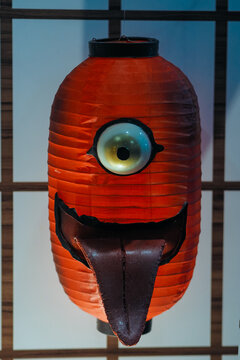 A red paper lantern styled as a Japanese yokai monster or Chochin obake