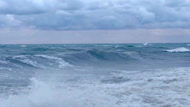 A large wave breaks toward the rocky shore on the Black Sea, illustrating high surf conditions for marine weather bulletins, beach hazard communication and water safety advisories for local visitors