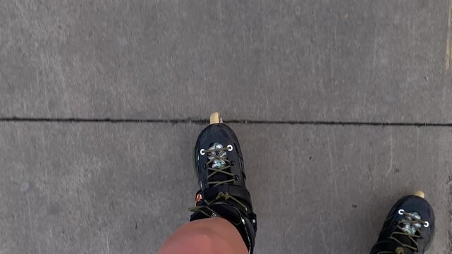 First-person view shows a skater gliding along a paved path, with a skate and yellow markings in view. Suitable for inline skate campaigns, action sport tutorials and urban mobility promotions.