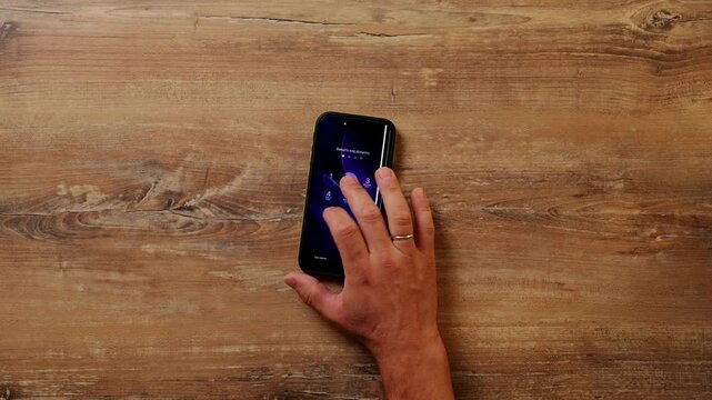 Man's hand interacts with smartphone screen to unlock and check the list before sliding it aside