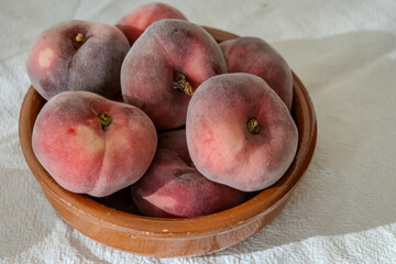 Flat peaches, Saturn sweet peaches from Mediterranean orchards, ripe Prunus persica seasonal fruit, harvest, orchard-grown fruit © barmalini