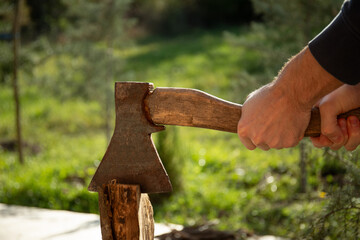 Fototapeta premium Individual uses axe to effectively split wood in a serene environment