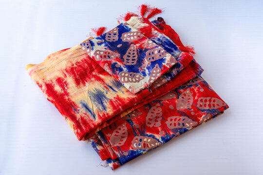 Stack of vibrant printed fabric unstitched dress material for women garments. South Asian fashion design and textile industry concept.