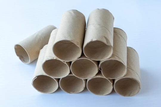 Stacked empty cardboard toilet paper rolls isolated on white background. Recycling and paper waste management concept.