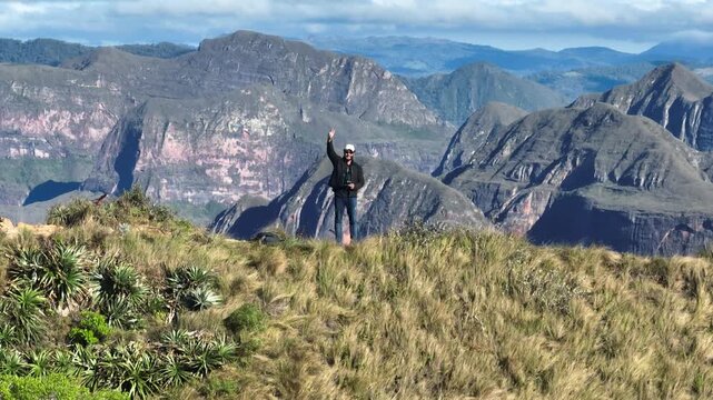 Traveler Overlooking the Dramatic Mountains of Codo de los Andes in Bolivia. Establishing Shot.