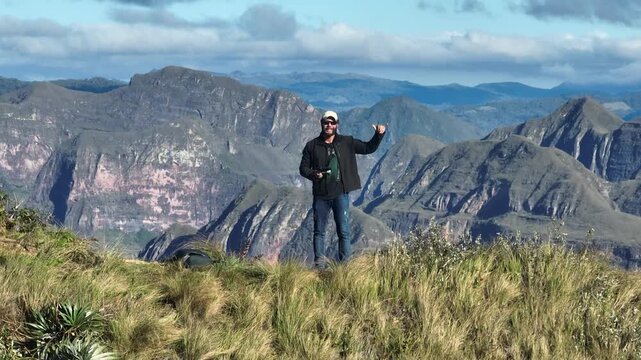Traveler Overlooking the Dramatic Mountains of Codo de los Andes in Bolivia. Establishing Shot.