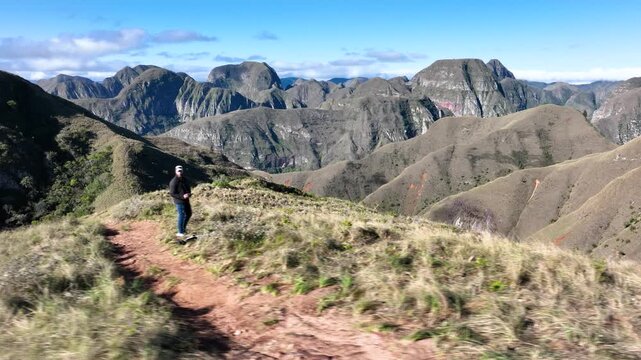 Traveler Overlooking the Dramatic Mountains of Codo de los Andes in Bolivia. Establishing Shot.