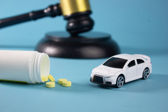 miniature car and pills, symbolizing hit-and-run accidents, illegal street racing, addict drugs, reckless driving, road safety laws, criminal liability, and legal consequences of dangerous
