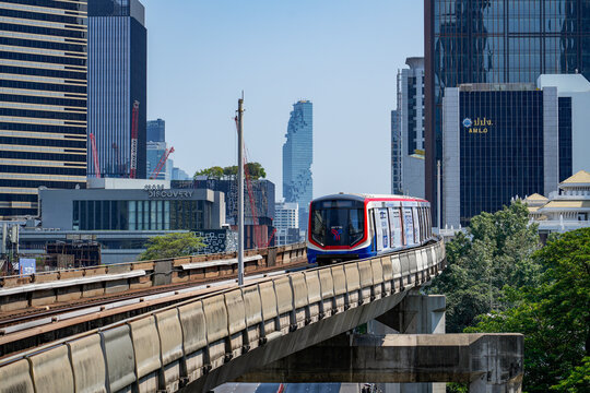 BTS Skytrain approaches a sweeping elevated curve above Bangkok traffic, with the MahaNakhon tower and modern glass office buildings forming the, Thailand, Bangkok, April 26, 2026.