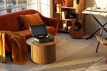 Nostalgia and leisure lifestyle, vintage record player on wooden table in cozy living room with musical instruments and warm sunlight in home interior © Pixel-Shot